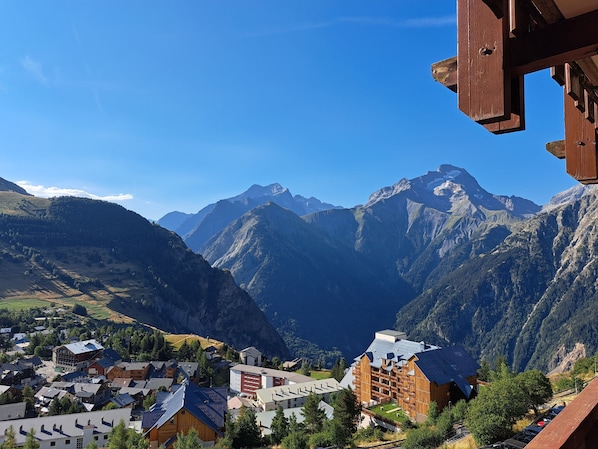 Un pueblo de montaña con edificios de madera tradicionales, una estación de esquí y vistas de las montañas circundantes.