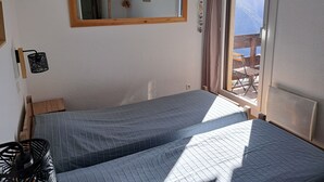 Una stanza con un letto, una finestra vista, una testiera in legno e uno specchio a parete.