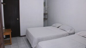 A small, clean room with two single beds, a wooden chair, and a door. - Hotel Manhattan Salinas Ecuador (Salinas)