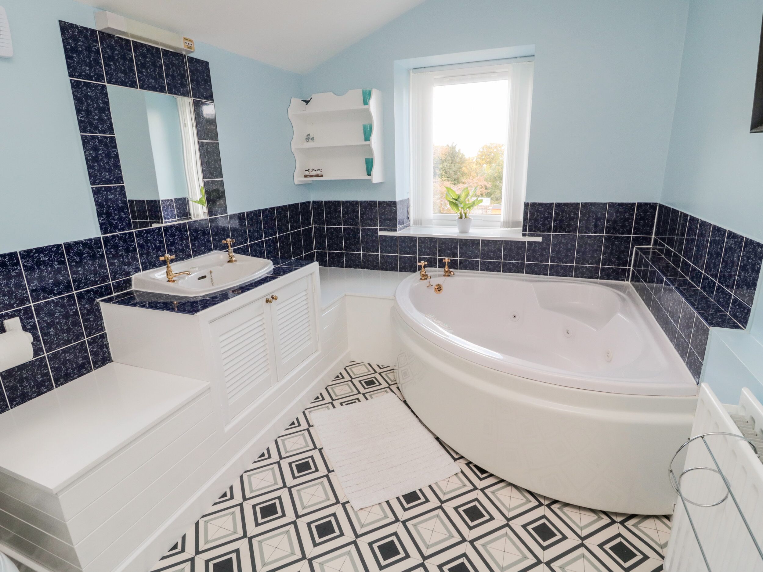 Une salle de bain moderne avec une baignoire sur pieds, un meuble-lavabo et un miroir.