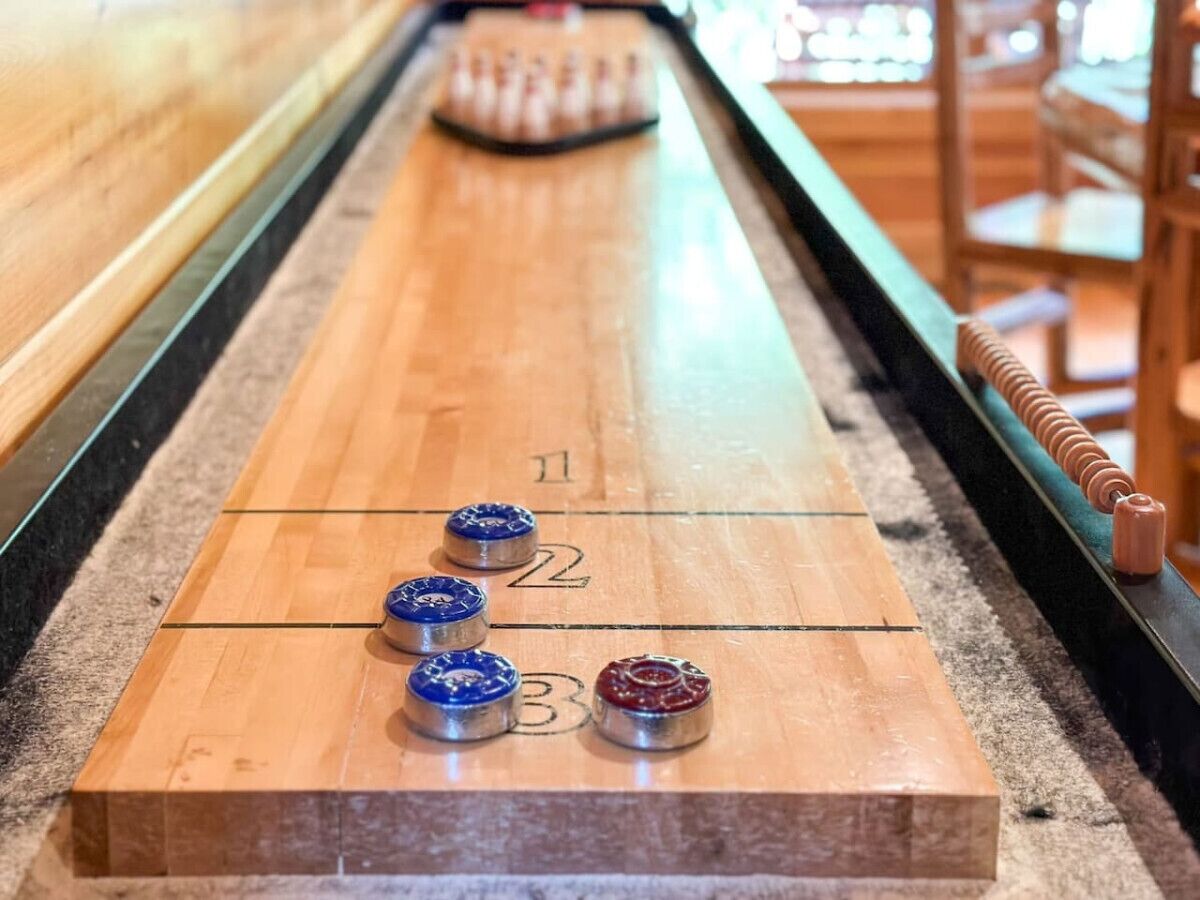 A shuffleboard table with numbered scoring areas and pucks.