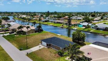 A residential area with houses, a canal, and a clear sky.