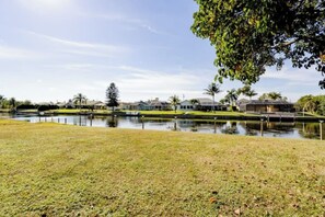 A residential area with houses, a body of water, and a grassy area.