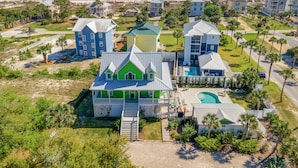 A coastal residential area with multiple houses, a swimming pool, and a beach view.