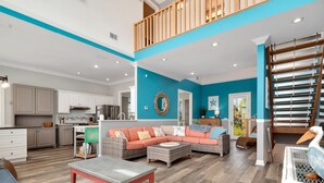 A spacious living area with a sofa, coffee table, and wicker furniture.