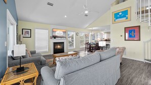 A living room with a fireplace, sofa, and dining area.