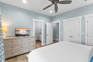 A bedroom with a bed, a dresser, a television, and a ceiling fan. - TipSea Turtle: 4th of July week now available as a Friday or Saturday check in! (Cape San Blas)