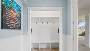 Un couloir avec un banc blanc, un porte-serviettes fixé au mur et une affiche avec du texte.
