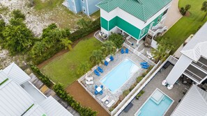 Una proprietà residenziale con piscina, area salotto esterna e giardino recintato.