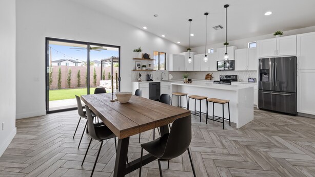A modern kitchen with white cabinets, a stainless steel refrigerator, and a wooden dining table with chairs. - This Must Be The Place ! (Phoenix)