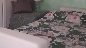 Una camera da letto con un letto, un comodino, una lampada e una finestra.