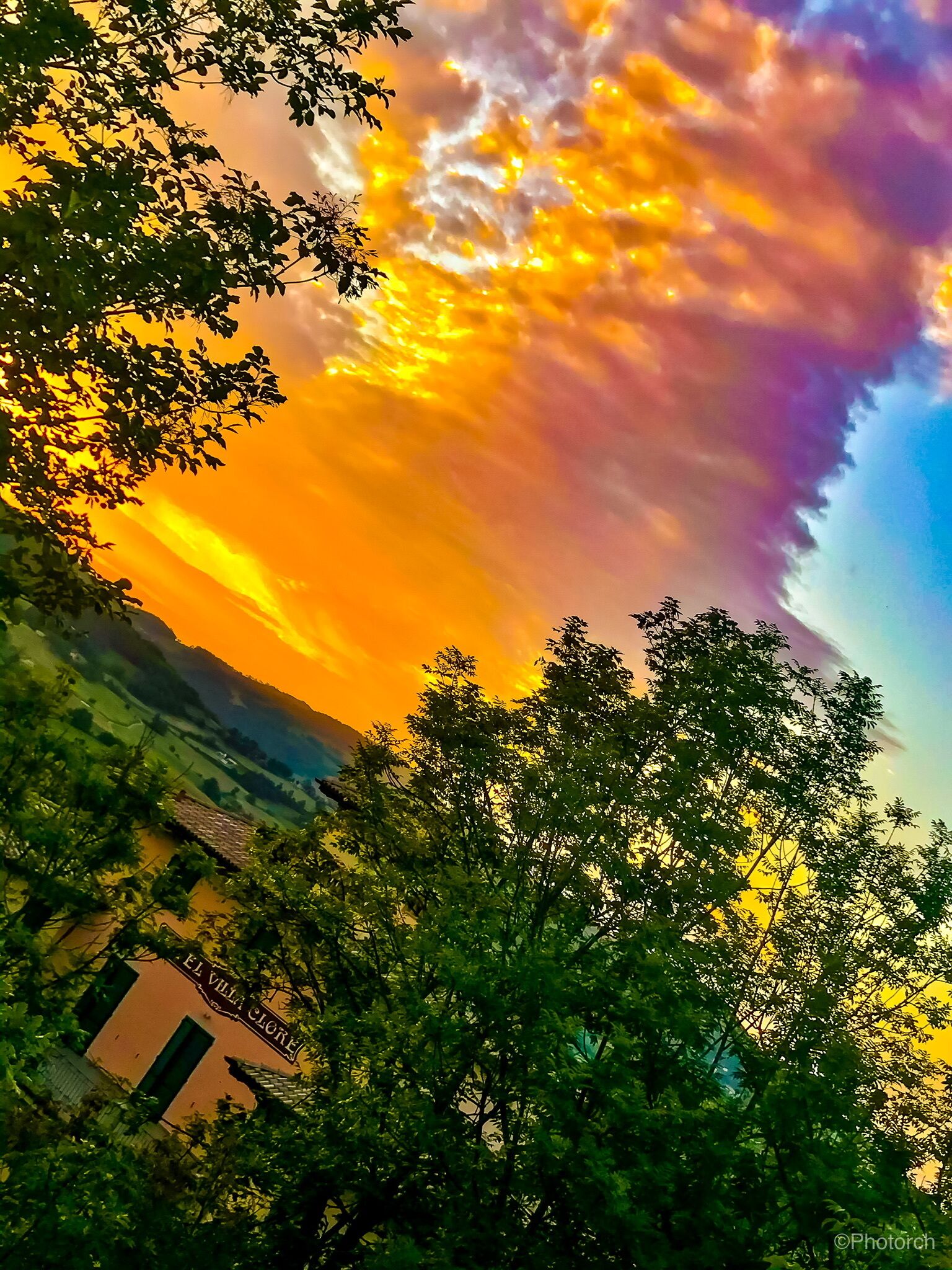 Vue d’El Villa Glorioso, avec la végétation luxuriante qui l’entoure et un ciel au coucher du soleil.