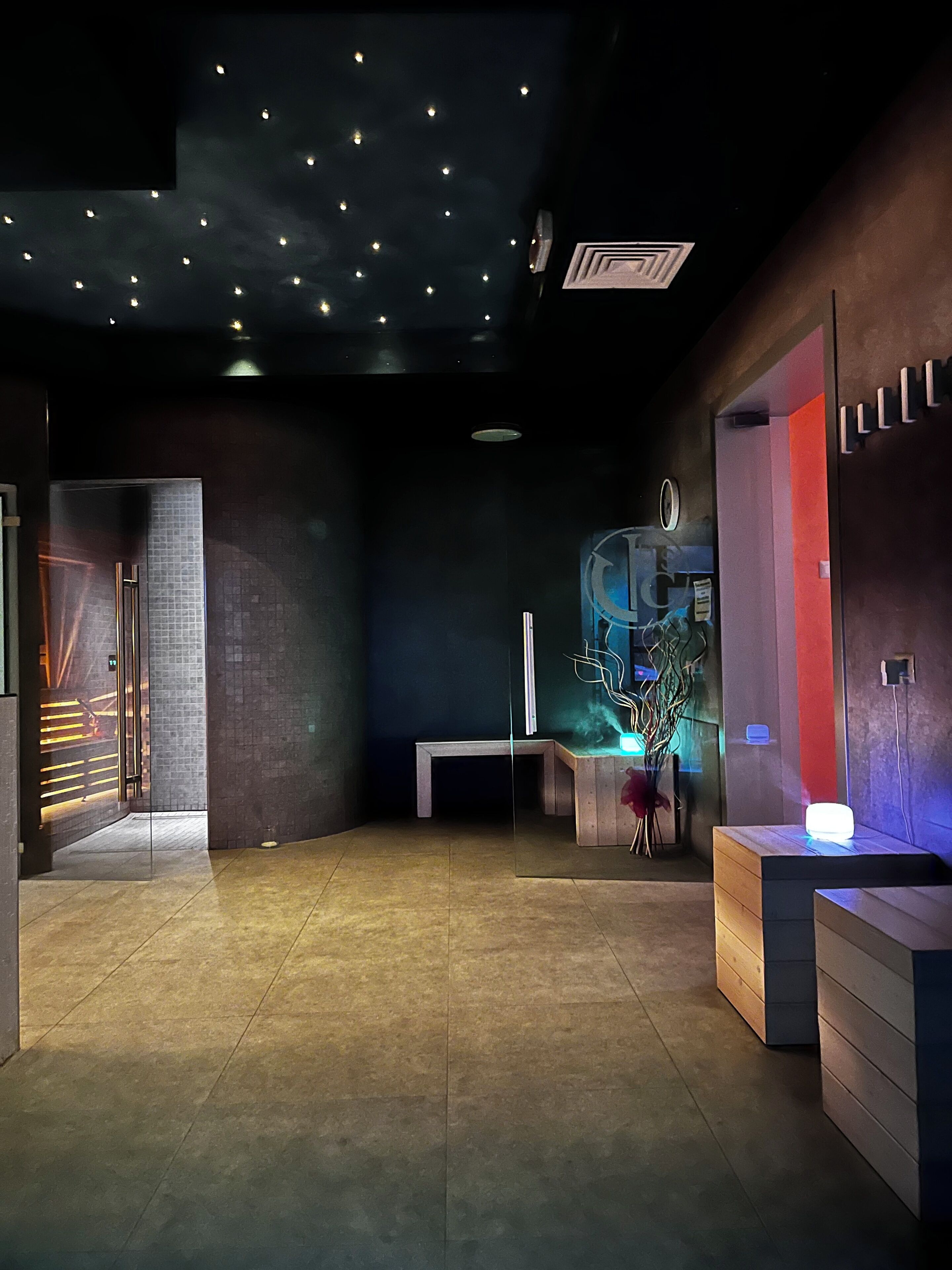 A modern lobby with a reception desk, a bench, and a decorative plant.