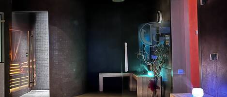 A modern lobby with a reception desk, a bench, and a decorative plant.