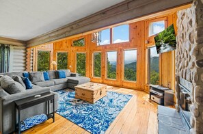 Flatscreentelevisie, een open haard, een videogameconsole en een stereo