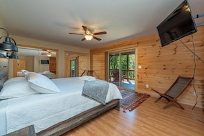 A bedroom with a bed, a ceiling fan, a television, and a view of the outdoors. - Stunning Mtn Views, Hot Tub+Fire Pit, WiFi, Grill! (Bakersville)