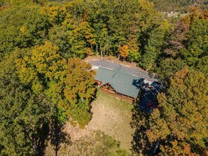 A lodge surrounded by dense forest, with a clear sky above. - Stunning Mtn Views, Hot Tub+Fire Pit, WiFi, Grill! (Bakersville)
