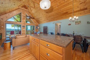 A spacious kitchen with a large island, wooden ceiling, and a view of the outdoors. - Stunning Mtn Views, Hot Tub+Fire Pit, WiFi, Grill! (Bakersville)
