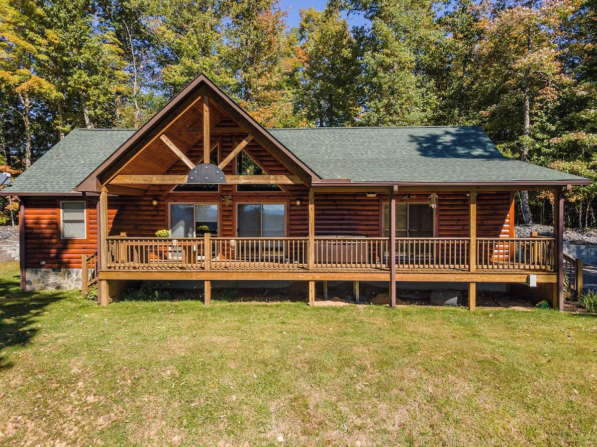 A log cabin with a deck and a covered porch.