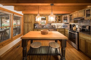 Enjoy cooking in this well-equipped kitchen with a central island, microwave, oven, and ample counter space.
