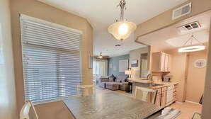 A dining area with a table and chairs, a kitchen with cabinets and a sink, and a living room with a sofa and a coffee table. - Private North Scottsdale Condo - Pool, Spa, Sauna & Outdoor Kitchen (Scottsdale)