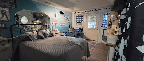 A bedroom with a bed, a dresser, and a window.