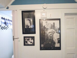 A wall with framed photographs and a door. - Island Parlor Inn Coastal Mid Century Studio (Savannah)