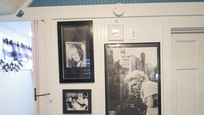 Un mur orné de trois photographies encadrées, dont une de Marilyn Monroe, et une porte avec un porte-manteau.