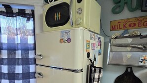 Une cuisine compacte équipée d’un réfrigérateur, d’un four à micro-ondes et d’un grille-pain.