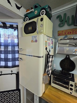 A compact kitchen with a refrigerator, a microwave, and a toaster.