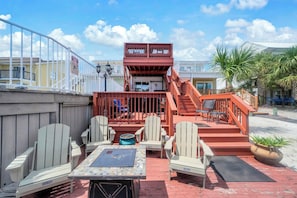 A patio area with outdoor seating, a staircase, and a view of the surrounding buildings.