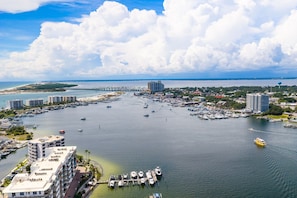 A marina with multiple docks and boats, surrounded by buildings and a clear sky.