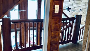 Una escalera de madera con barandilla que da a un espacio al aire libre.