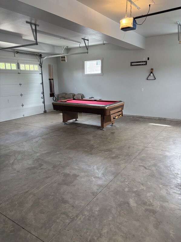 A spacious indoor area with a pool table, a ceiling-mounted projector, and a window providing natural light. - Colorado views, Downtown fun! (Windsor)