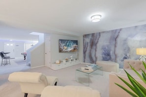 Una sala de estar moderna con una pared de mármol, una mesa de centro de vidrio y un sofá.