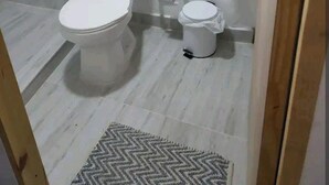 Une petite salle de bain propre, équipée de toilettes, d’un bidet et d’un lavabo.