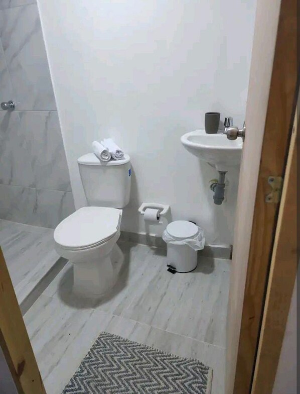 A small, clean bathroom with a toilet, bidet, and sink.