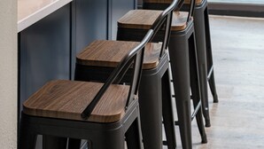 Un'area pranzo moderna con un tavolo lungo, diverse sedie e vista sulla strada.
