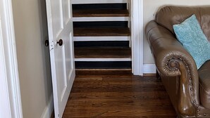 A staircase leading to a loft bedroom with a wooden floor and a brown leather couch with a blue pillow. - Alan's Corner - 4 bedroom / 4 bath, pool, less than 5 minutes to Dreams Park (Cooperstown)