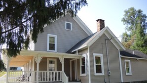 A two-story house with a porch and a chimney. - Alan's Corner - 4 bedroom / 4 bath, pool, less than 5 minutes to Dreams Park (Cooperstown)