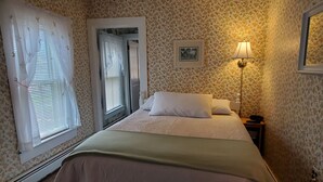 A bedroom with a bed, a nightstand, a lamp, and a picture on the wall. - Apple Tree Apt 2, Charming 2nd fl apt, under 5 minutes to Dreams Park (Milford)
