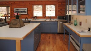 Une cuisine moderne avec des murs en bois, un îlot central et des armoires bleues.
