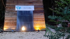 Une cabane en bois avec une enseigne indiquant « XCHBL » et une petite lumière à l’entrée.