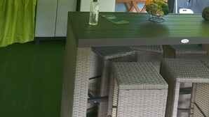 Una cocina compacta equipada con refrigerador, microondas y una pequeña mesa de comedor.