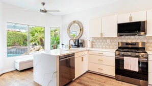 Een moderne keuken met een inbouw vaatwasser, roestvrijstalen apparatuur en een groot kookeiland.