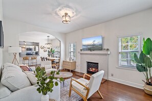 TV connectée, cheminée, livres, chaîne hi-fi