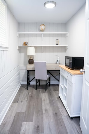 Effortlessly equipped kitchen with a microwave, cabinet, and table.