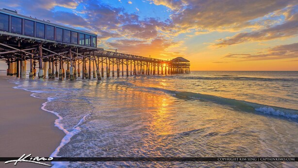 A pier extending into the ocean with a building on one end and a gazebo on the other.