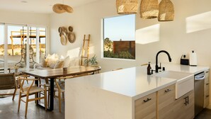 A modern kitchen with a large island, white cabinetry, and a view of the outdoors. - Casa Bella - Private Getaway w/ Pool - Spa - Views (Landers)