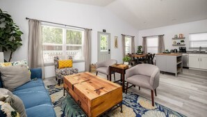 Un salon moderne avec un canapé bleu, une table basse en bois et un coin repas comprenant une table et des chaises.